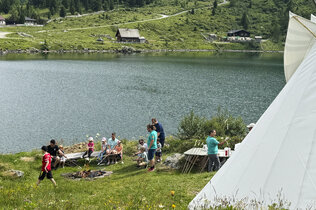 Steckerlbrot-Grillen mit vielen Kindern am See in den Bergen. 