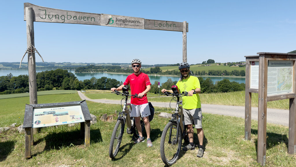 Zwei Männer mit ihren Fahrrädern, ein See im Hintergrund