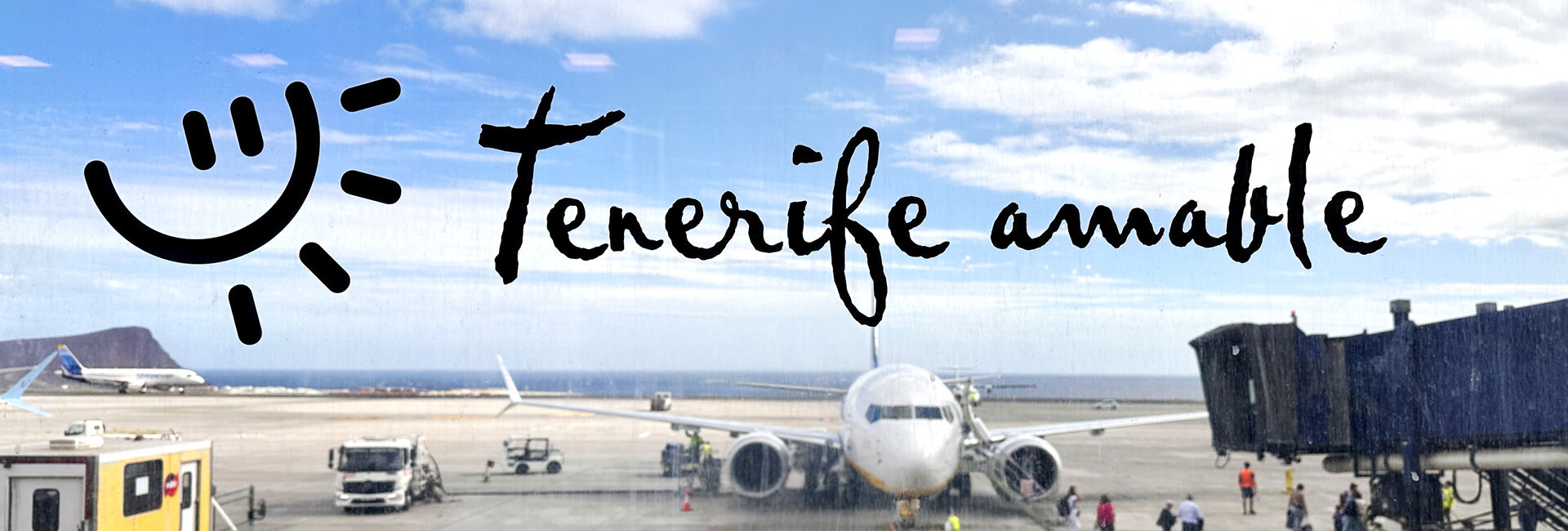  Eine große Scheibe aufs Rollfeld des Flughafens mit dem Text: Tenerife amable.