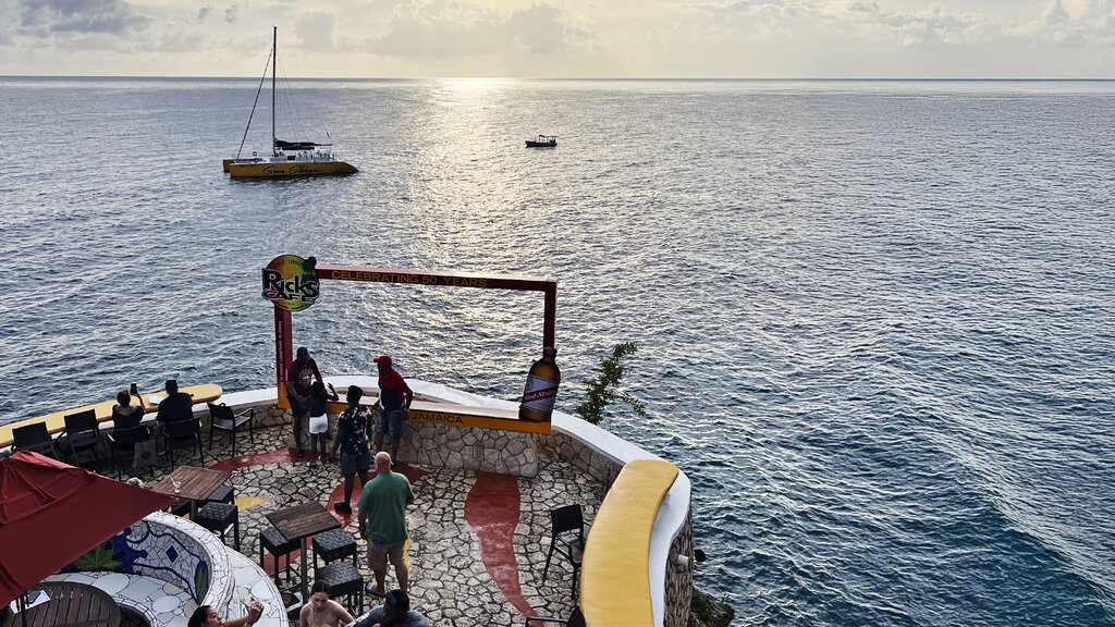 Eine Bar am Meer mit Blick auf ein Segelboot.
