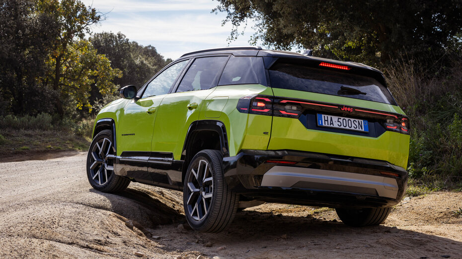 Ein grüner Jeep Compass steht auf unwegsamen Gelände.