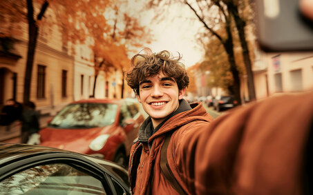 Ein junger Bursche macht auf der Fahrbahn in einer Stadt ein Selfie