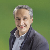 Ein Mann in Hemd und Jacke lächelt