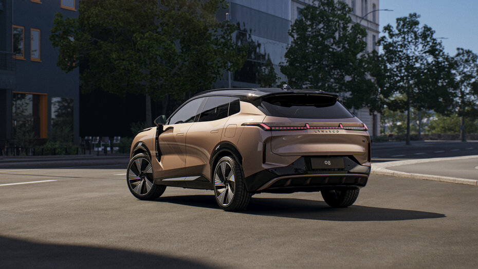 Ein kupferfarbener Lynk & Co steht auf einer Straße in der Stadt.