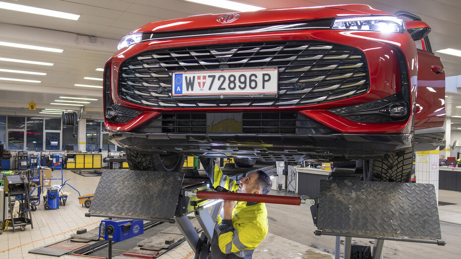 Foto zeigt einen ÖAMTC-Techniker, der am Stützpunkt das Testfahrzeug inspiziert.