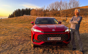 Bild zeigt einen auto-touring Redakteur bei Sonnenuntergang vor dem Testauto stehend.