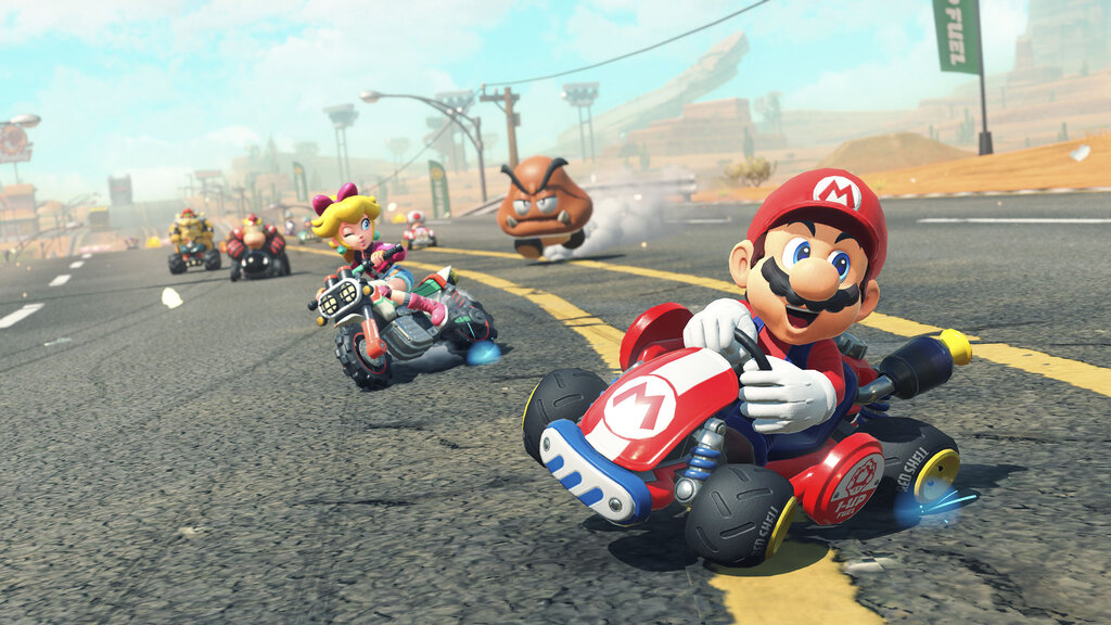 Screenshot aus Mario Kart World. Mario fährt in einem roten Auto in die Kurve.