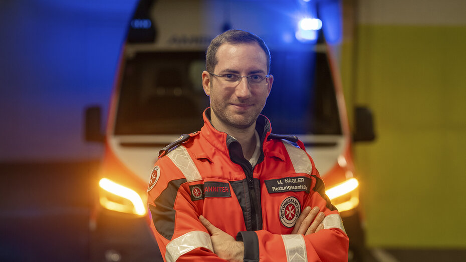 Verkehrsexperte und Rettungssanitätet Matthias Nagler steht in seiner Johanniter Uniform vor einem Rettungswagen.