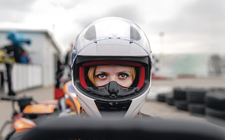 Frau mit weißem Sturzhelm im Cockpit
