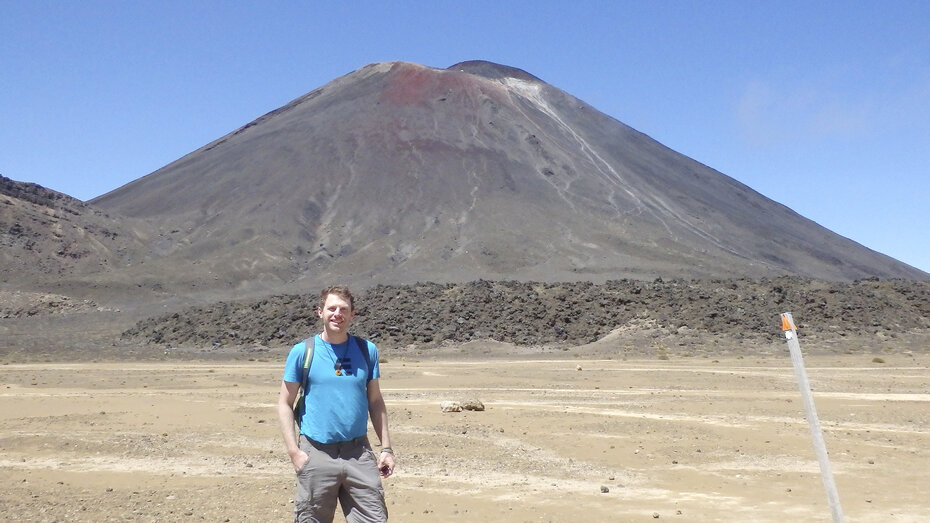 Ein Mann steht vorm Vulkan Mt. Nagauruhoe.