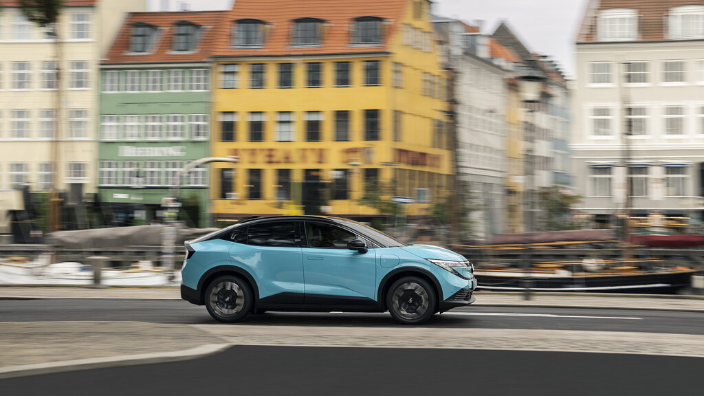 Ein türkiser Nissan Leaf fährt durch Kopenhagen