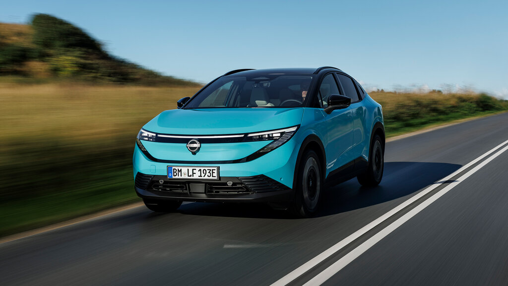 Ein türkiser Nissan Leaf von vorn auf einer Landstraße