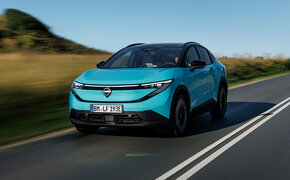 Ein türkiser Nissan Leaf von vorn auf einer Landstraße