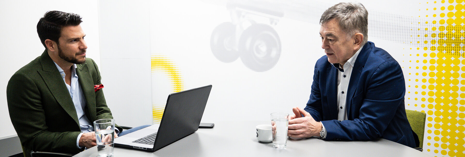 Brigadier Walter J. Unger und auto touring Chefredakteur Stephan Höckner sitzen plaudernd in einem hellen Besprechungsraum.