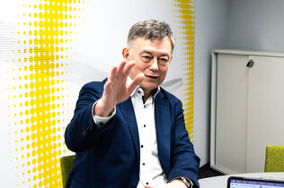 Brigadier Walter J. Unger gestikulierend beim Gespräch in einem hellen Besprechungszimmer.