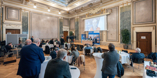 Eine Pressekonferenz in einem prunkvollen Saal