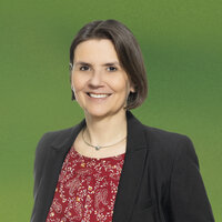 Eine Frau mit dunklen Haaren im Blazer