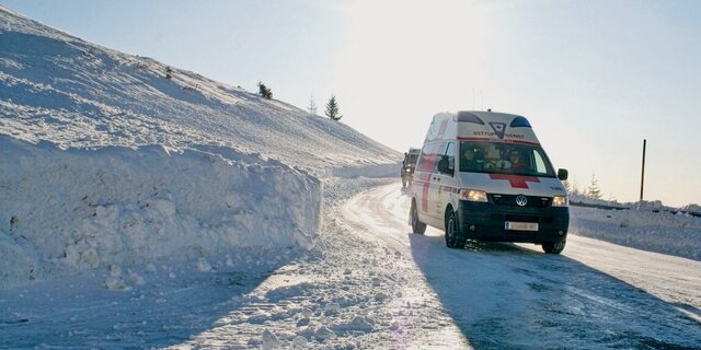 Ein Rettungswagen des österreichischen Roten Kreuz in winterlicher Landschaft.
