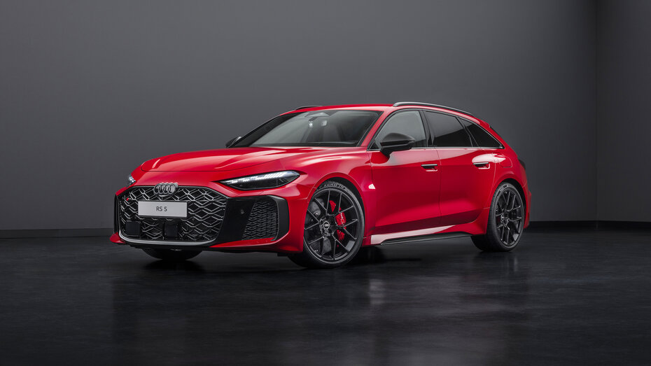 Ein roter Audi RS 5 Avant steht in einem dunklen Studioraum.