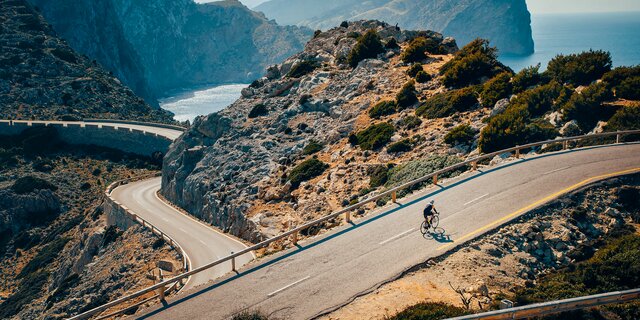Ein Radfahrer auf einer mediterranen Bergstraße.