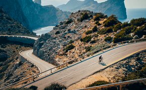 Ein Radfahrer auf einer mediterranen Bergstraße.