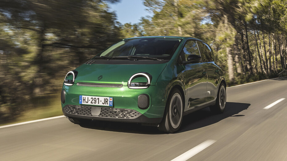 Ein grüner Renault Twingo fährt auf einer Landstraße.