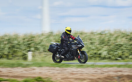 Grauer Sporttourer fahrend von schräg vorne fotografiert.