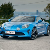Eine blaue Alpine A110 steht auf einem Parkplatz