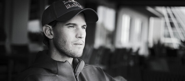 Schwarz-weiß-Foto des Ex-Tennisspielers Dominic Thiem, wie er in die Ferne blickt.