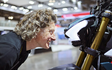 Mann blickt direkt in den Scheinwerfer eines Motorrads.