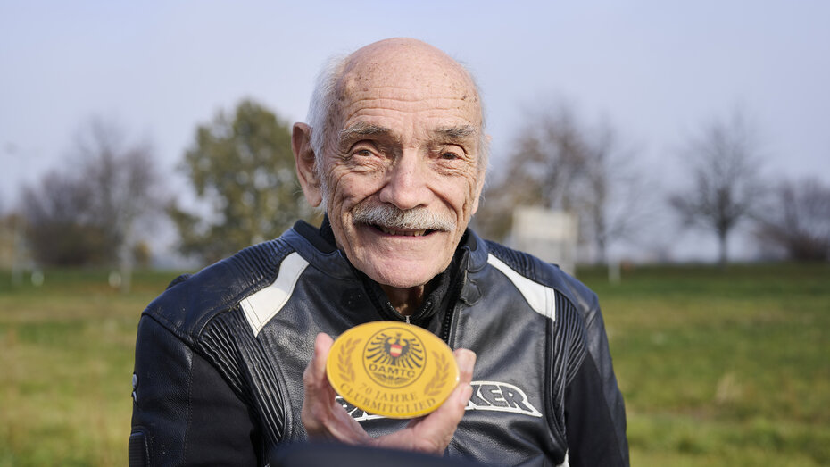 Ein langjähriges ÖAMTC-Mitglied zeigt die Plakette seiner 70-jährigen Mitgliedschaft
