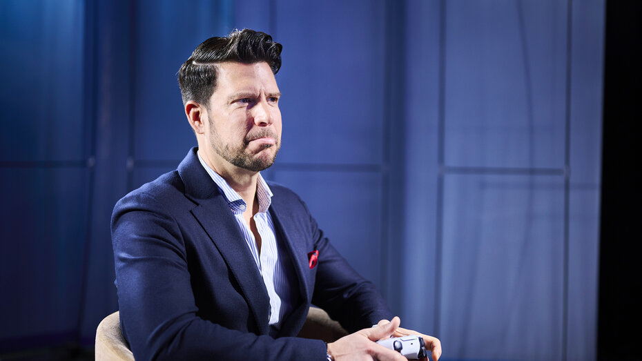 Chefredakteur Stephan Höckner sitzt mit Controller und spielt. Er hat die Miene verzogen.