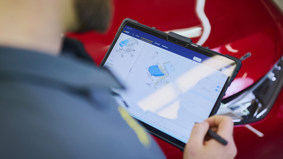 Blick über die Schulter eines Mannes auf einen Tablett-PC. 