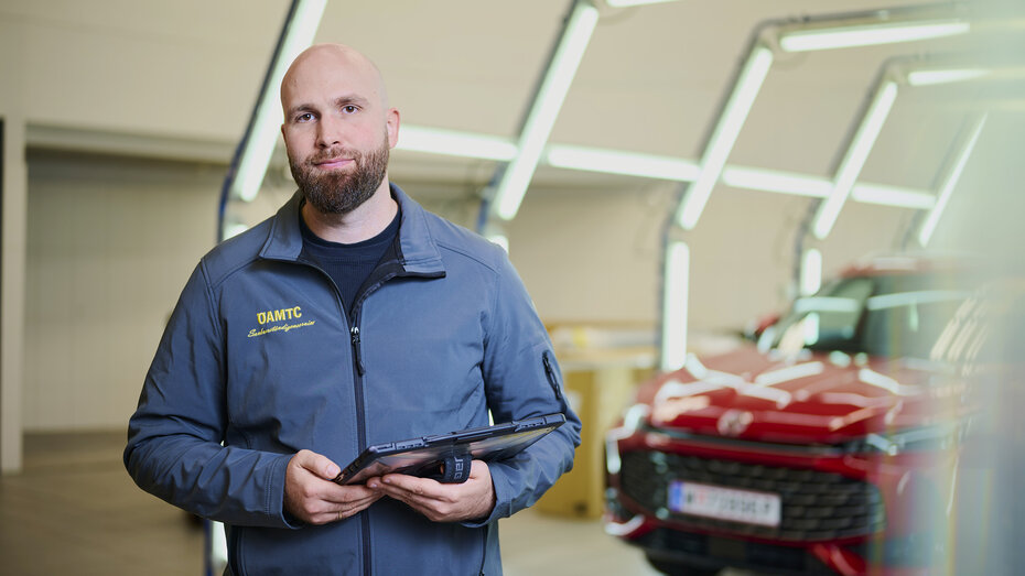 Schadensbegutachter David Kaiser im Lichttunnel mit Tablett in der Hand. 
