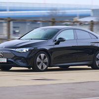 Ein schwarzer Mercedes CLA fährt an einem Zaun vorbei