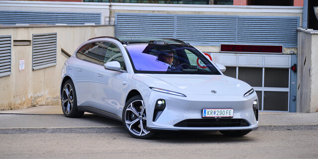 Ein hellblauer Nio ET5 Touring steht vor der Ausfahrt einer Tiefgarage.