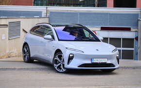 Ein hellblauer Nio ET5 Touring steht vor der Ausfahrt einer Tiefgarage.