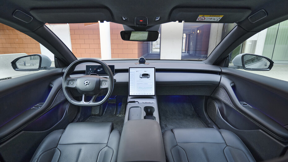 Cockpit eines Nio ET5 Touring mit 12,8-Zentral-Touchscreen und Landschaft aus dunklem Leder.