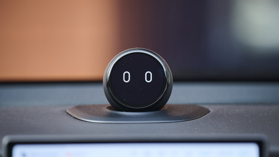 Der Nomi Mate: Eine Kugel mit Bildschirm, auf der sich ein digitales Gesicht befindet, auf der Mitte des Armaturenbrettes eines Nio ET5 Touring.