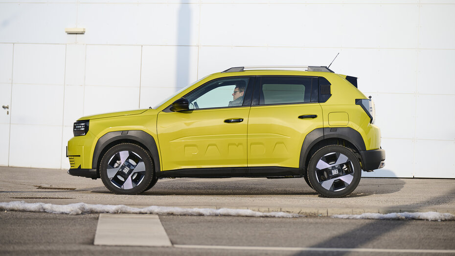 Ein gelber Fiat Grande Panda steht vor einer weißen Wand.