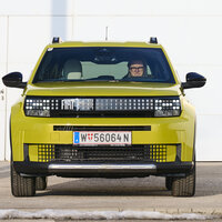 Ein gelber Fiat Grande Panda steht vor einer weißen Wand.