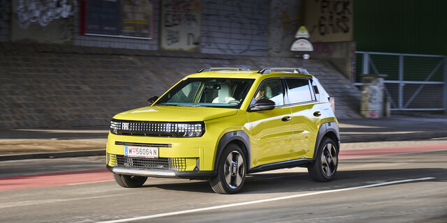 Ein gelber Fiat Grande Panda fährt durch die Stadt.
