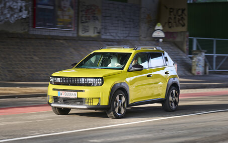 Ein gelber Fiat Grande Panda fährt durch die Stadt.