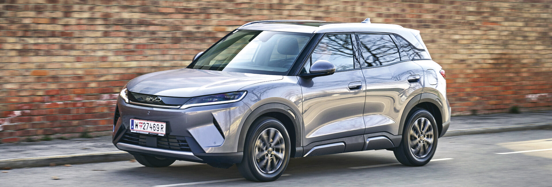 BYD Atto 2,  in grau silber, Aufnahme in Fahrt seitlich auf Fahrerseite