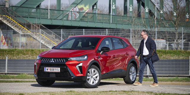 Mitsubishi Grandis in roter Farbe, schräge Ansicht mit Redakteur Christian Stich