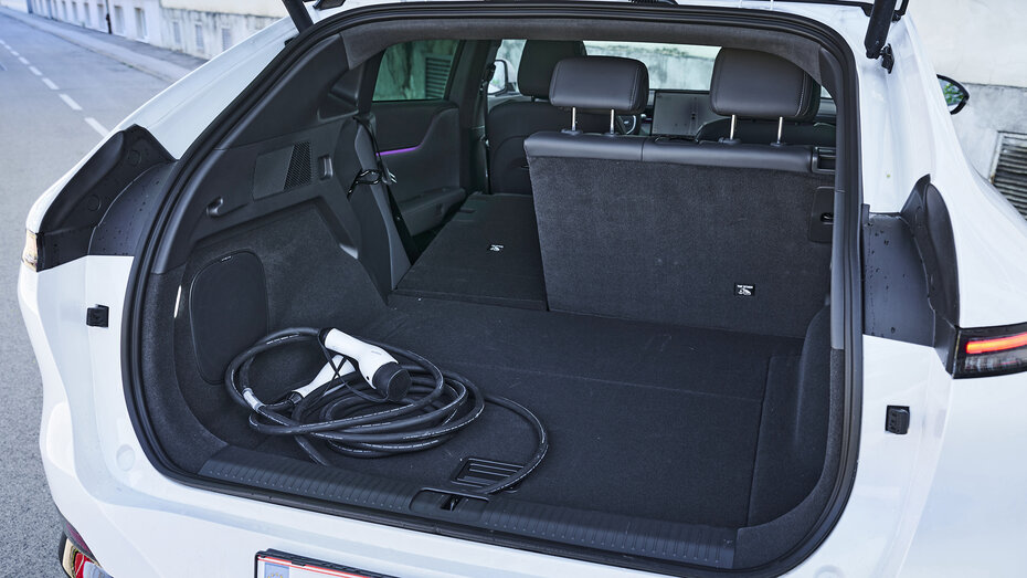 Kofferraum eines weißen Xpeng G6 mit umgeklapptem linken hinteren Sitz.