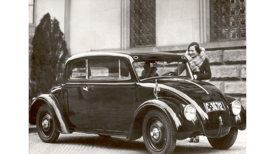 Ein Auto, das aussieht wie ein sehr früher VW Käfer.