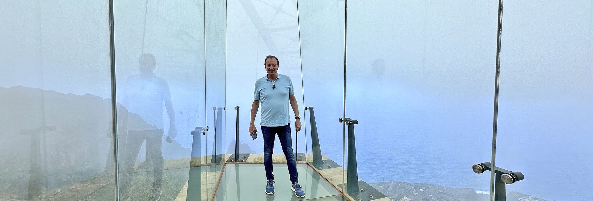 Der Reporter steht auf dem Glasboden des Aussichtsfingers, unter ihm geht es 600 Meter in die Tiefe.