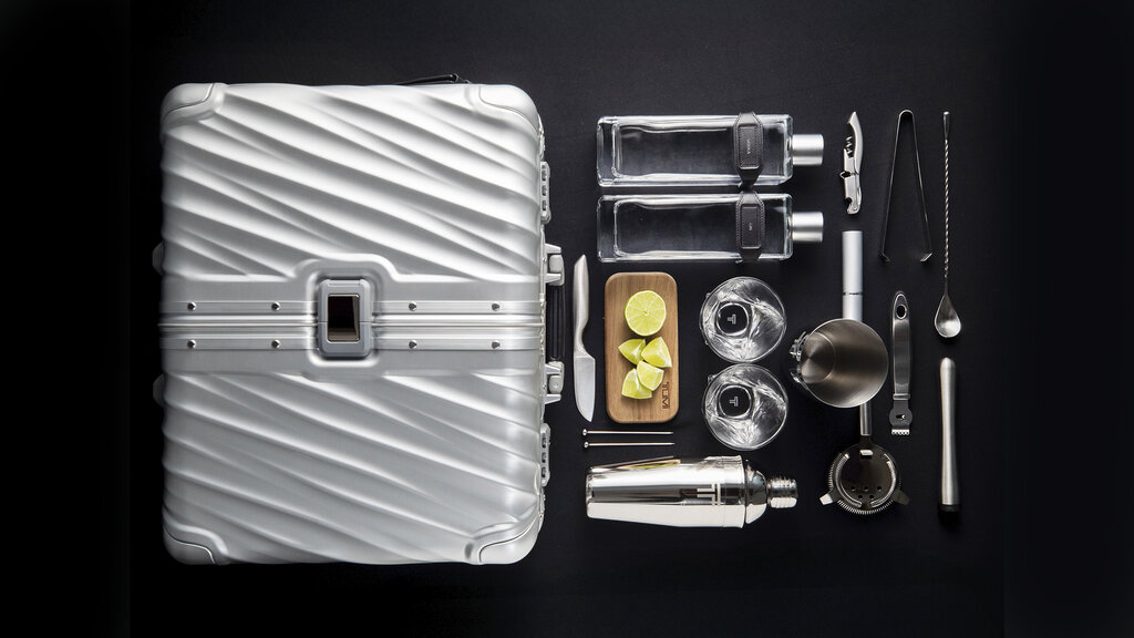 Imagebild Tumi Reisebar. Inhalt der Bar und Koffer sind nebeneinander aufgereiht.