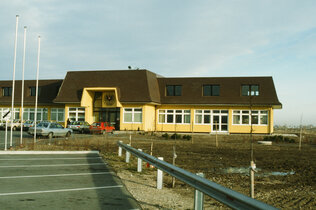 Ein großes gelbes ÖAMTC-Gebäude, Parkplätze und Autos. Das war das erste Gebäude des Fahrtechnikzentrums in Teesdorf.